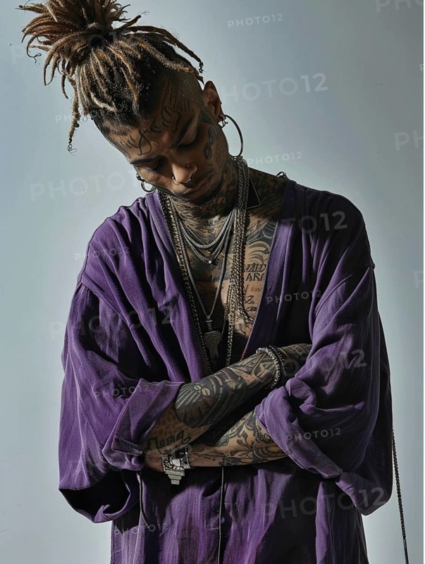 Man with dreadlocks and tattoos wearing a purple shirt, arms crossed and looking down in a moody pose, AI generated