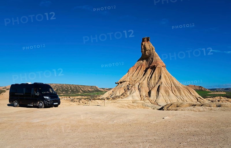 Motorhome in a barren desert landscape with striking rock formations and a clear blue sky, Castildetierra, Bardenas Reales Natural Park, desert, semi-desert, Navarre, Nafarroa, UNESCO Biosphere Reserve, Spain, Europe