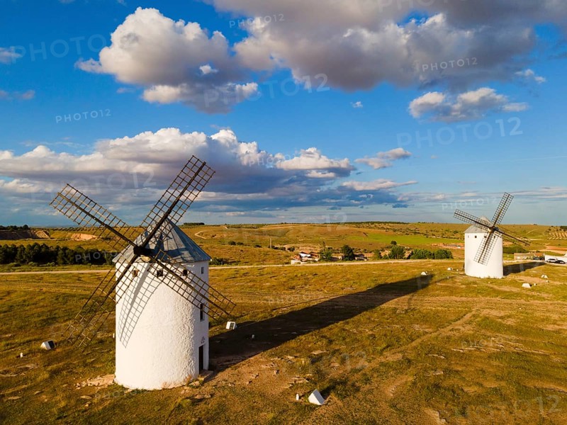 Two windmills stand in a wide landscape under a partly cloudy blue sky, aerial view, windmills, Campo de Criptana, Ciudad Real province, Castilla-La Mancha, Route of Don Quixote, Spain, Europe