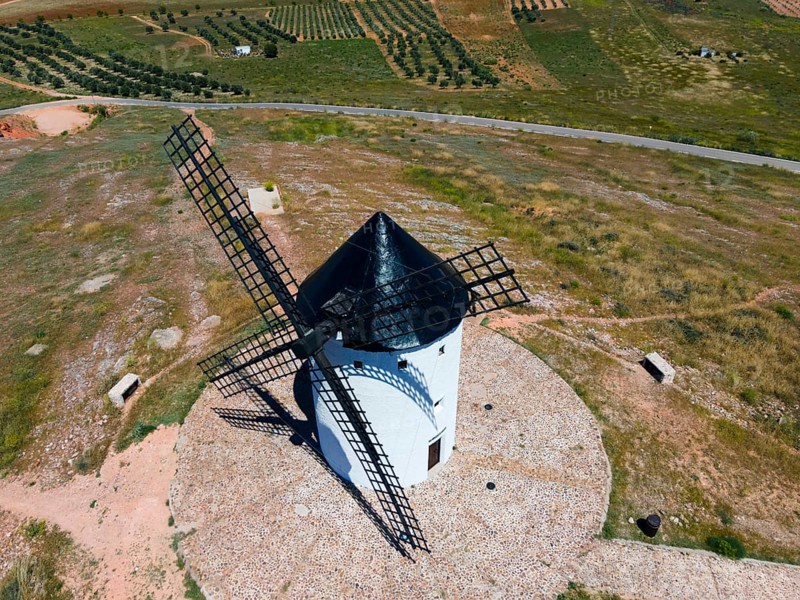 Aerial view of a white windmill in a green, rural landscape under a sunny sky, aerial view, Alcazar de San Juan, Ciudad Real, Castilla-La Mancha, Route of Don Quixote, Spain, Europe