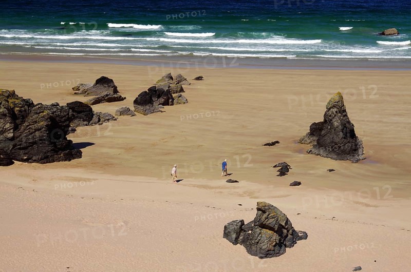 People walking on a beach with big rocks and waves in the background, Durness, Scotland, Great Britain