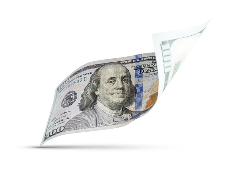 One hundred dollar bill floating down to surface with drop shadow isolated on a white background