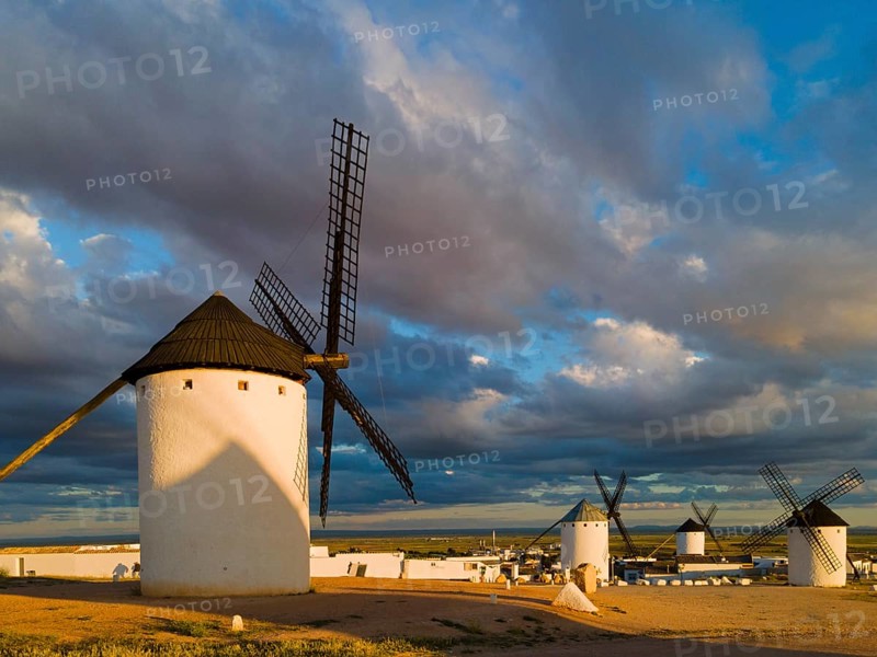 White windmills in an open landscape with dramatic clouds and sunbeams in the background, windmills, Campo de Criptana, Ciudad Real province, Castilla-La Mancha, Route of Don Quixote, Spain, Europe