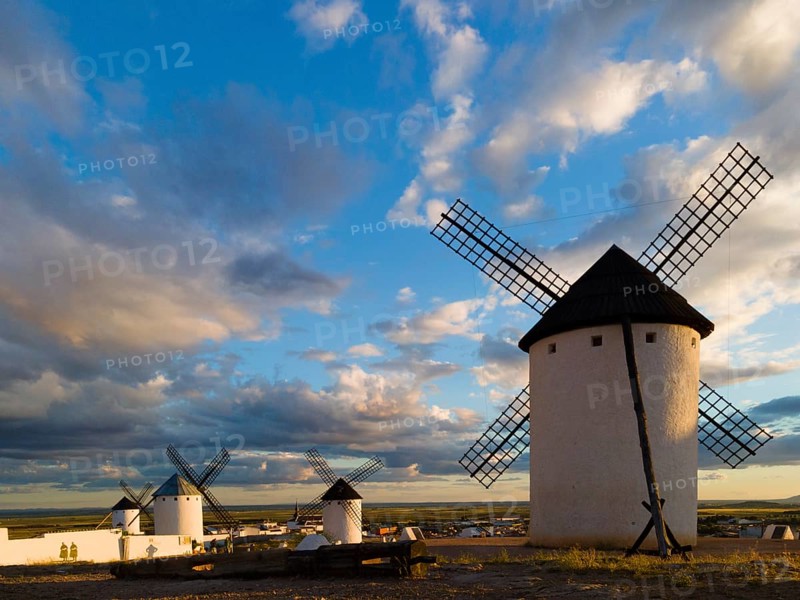 Several windmills stand in an open landscape under a dramatic sky at sunset, Windmills, Campo de Criptana, Ciudad Real province, Castilla-La Mancha, Route of Don Quixote, Spain, Europe