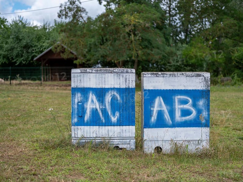 Electricity boxes with the spray-painted letters AC and AB on Lake Jersleben next to a campsite, Jersleben, Saxony-Anhalt, Germany, Europe