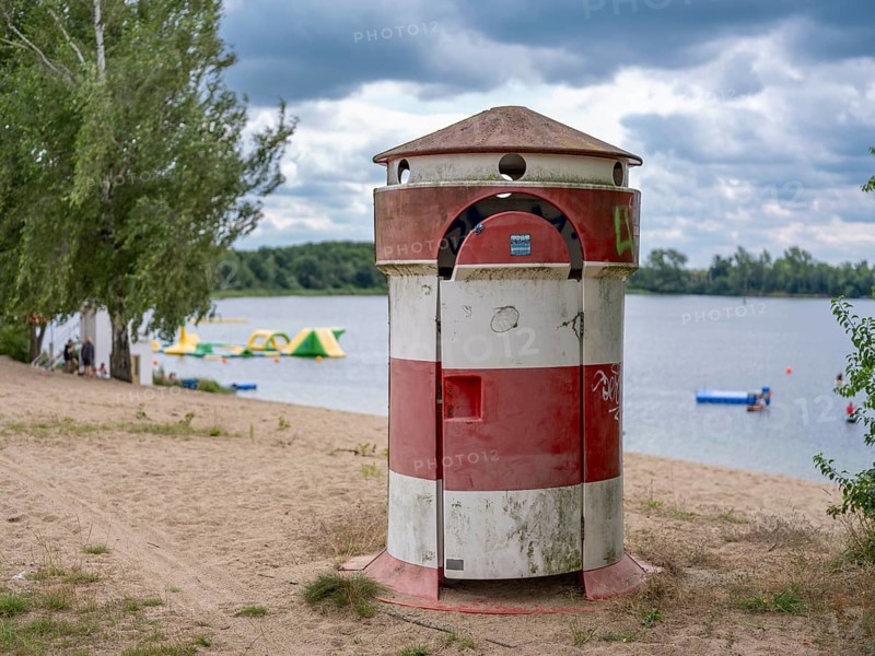 Old round red-white-ringed changing room from GDR times in the shape of a lighthouse on the shore of Lake Jersleben next to a campsite, Jersleben, Saxony-Anhalt, Germany, Europe