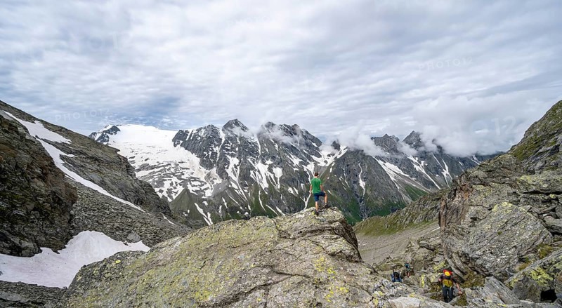 Mountaineer in a rocky saddle, Lapenscharte with view of mountain peaks and glacier into the valley Floitengrund, Berliner Höhenweg, Zillertal Alps, Tyrol, Austria, Europe