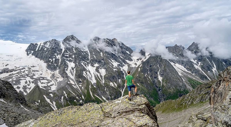 Mountaineer in a rocky saddle, Lapenscharte with view of mountain peaks and glacier into the valley Floitengrund, Berliner Höhenweg, Zillertal Alps, Tyrol, Austria, Europe