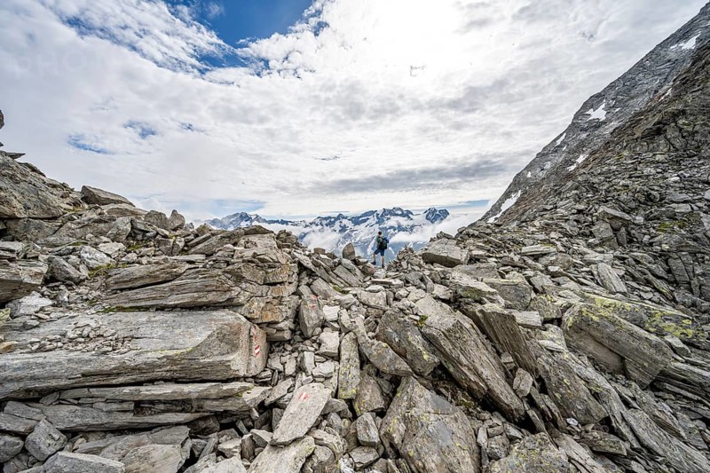 Mountaineer in a rocky saddle, Lapenscharte with view of mountain peaks, Berliner Höhenweg, Zillertal Alps, Tyrol, Austria, Europe