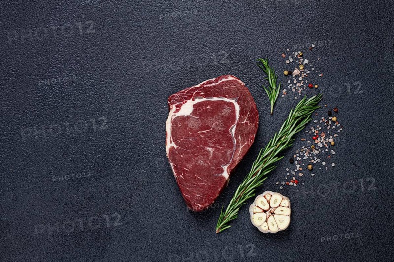 Raw steak, beef steak, rib eye steak, on the table, top view, no people, on a dark background