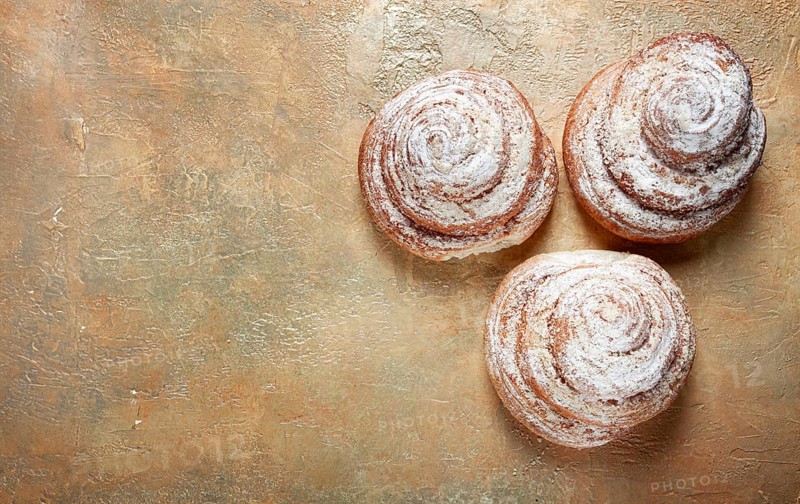 Bakery product, lemon twist, with white glaze, sweet bun, muffin, pastries, top view, no people