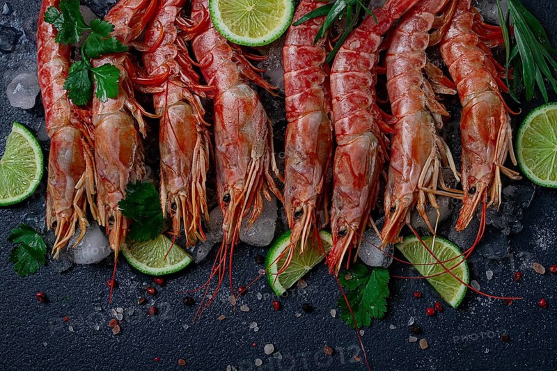 Langoustines, Australian, freshly frozen on ice, top view, lime and greens