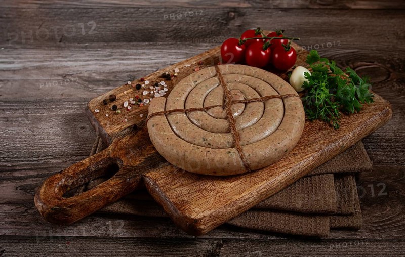Raw spiral sausages, on a wooden board, top view, no people