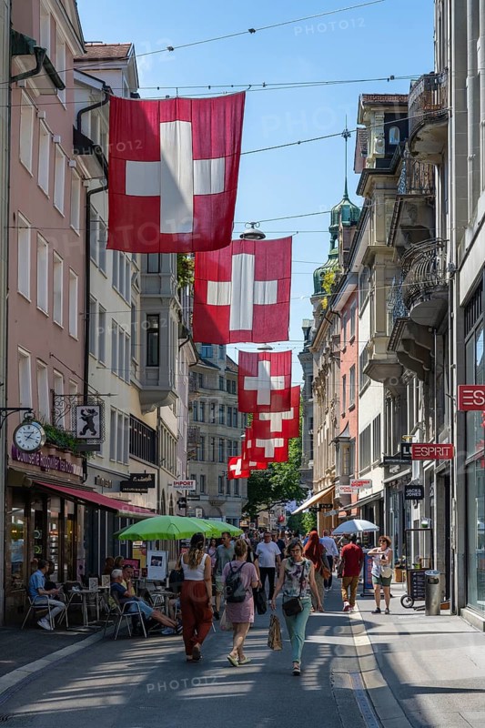 The Multergasse, pedestrian zone, shopping alleyway, decorated with Swiss national flags in the monastery quarter, historic old town of Sankt Gallen, Canton of St. Gallen, Switzerland, Europe