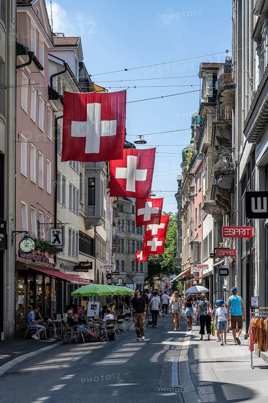 The Multergasse, pedestrian zone, shopping alleyway, decorated with Swiss national flags in the monastery quarter, historic old town of Sankt Gallen, Canton of St. Gallen, Switzerland, Europe