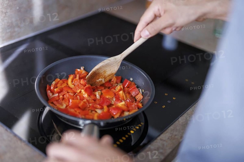 Cooking theme. A man stirs in a pan. Berlin, 01.08.2024