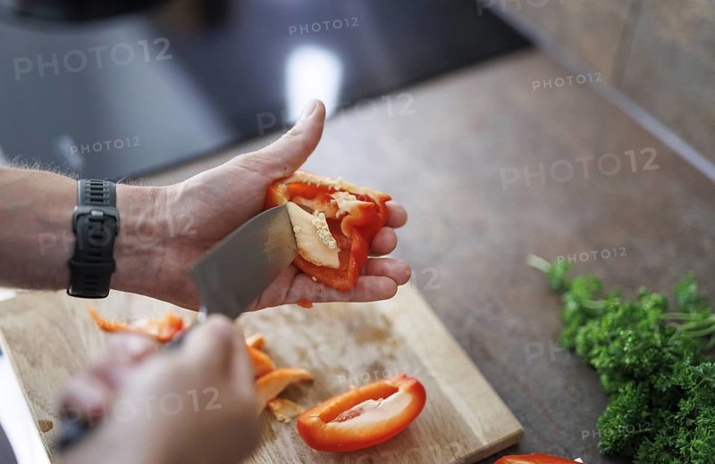 Cooking topic. A man cuts a sweet pepper. Berlin, 01.08.2024