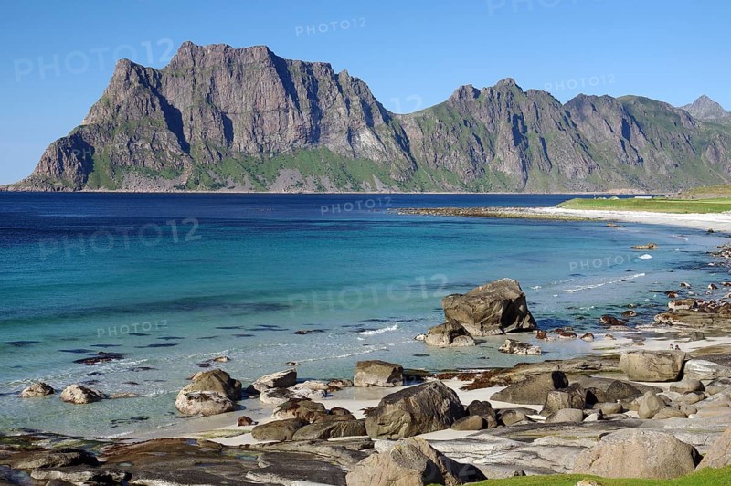 Wide beach with clear blue water and rocks, while impressive mountains form the background, Uttakleiv Beach, Leknes, Lofoten, Nordland, Norway, Europe
