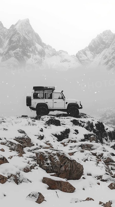 A white Land Rover parked on a rocky, snow-covered hill with misty mountains in the background, AI generated