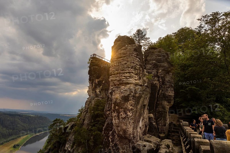 The Bastei is a rock formation with a viewing platform in Saxon Switzerland on the right bank of the River Elbe in the municipality of Lohmen between the spa town of Rathen and the town of Wehlen. It is one of the most visited tourist attractions in Saxon Switzerland. Dramatic sky over the Bastei. ourists on the new viewing platform, Saxon Switzerland, Rathen, Saxony, Germany, Europe