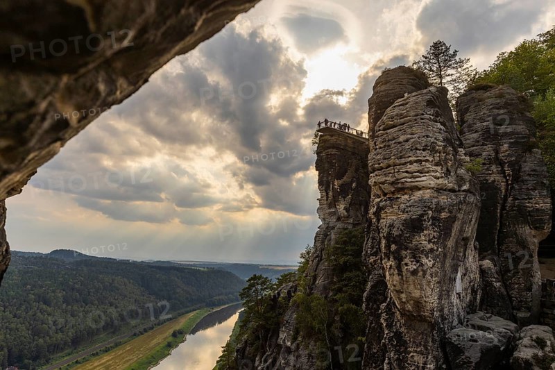 The Bastei is a rock formation with a viewing platform in Saxon Switzerland on the right bank of the River Elbe in the municipality of Lohmen between the spa town of Rathen and the town of Wehlen. It is one of the most visited tourist attractions in Saxon Switzerland. Dramatic sky over the Bastei. ourists on the new viewing platform, Saxon Switzerland, Rathen, Saxony, Germany, Europe