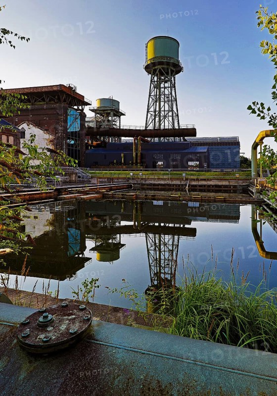 The water tower is reflected in the water basins at the Jahrhunderthalle in Westpark, Industrial heritage, Bochum, Ruhr area, North Rhine-Westphalia, Germany, Europe