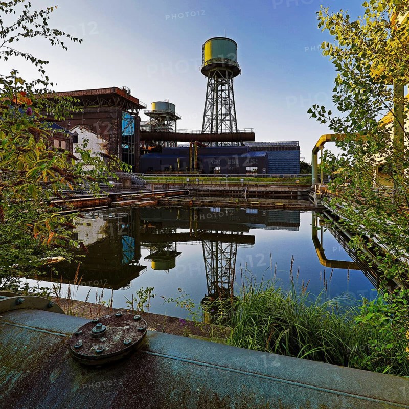 The water tower is reflected in the water basins at the Jahrhunderthalle in Westpark, Industrial heritage, Bochum, Ruhr area, North Rhine-Westphalia, Germany, Europe