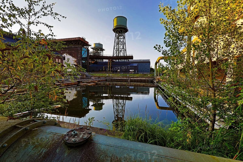 The water tower is reflected in the water basins at the Jahrhunderthalle in Westpark, Industrial heritage, Bochum, Ruhr area, North Rhine-Westphalia, Germany, Europe