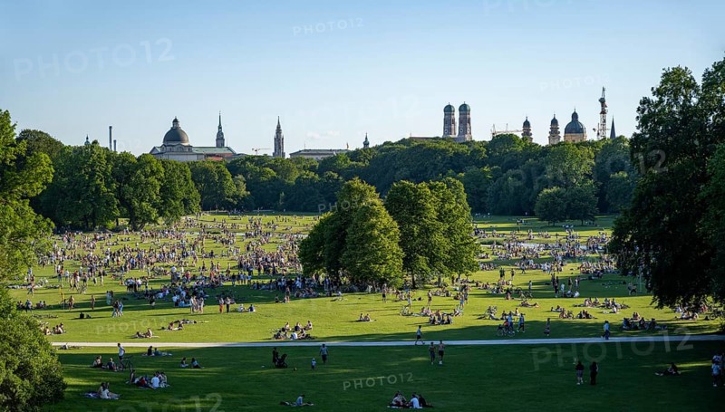 View from the Monopteros in the English Garden, meadows full of visitors on a summer day, Munich city view with dome of the state chancellery, towers of the Church of Our Lady and Theatine Church, Munich, Bavaria, Germany, Europe