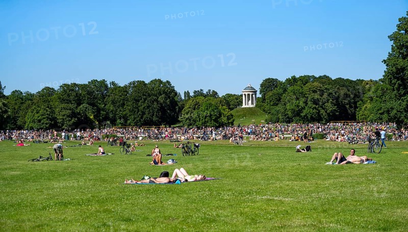 Many people in a meadow in the English Garden, people enjoying the summer day in the park behind Monopteros, Munich, Upper Bavaria, Bavaria, Germany, Europe