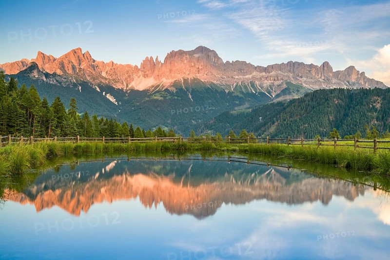 Mountains reflected in a small mountain lake, sunset, evening light, Wuhnleger Weiher, view of rose garden, Dolomites, South Tyrol, Italy, Europe