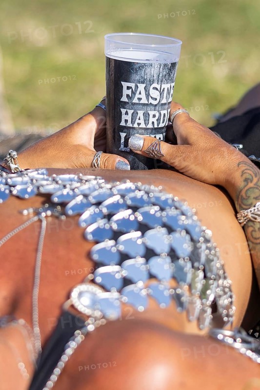 A festival visitor from Norway relaxes lying down with a Wacken cup in her hand at the Wacken Open Air in Wacken. The traditional metal festival takes place from 31 July to 2 August 2024