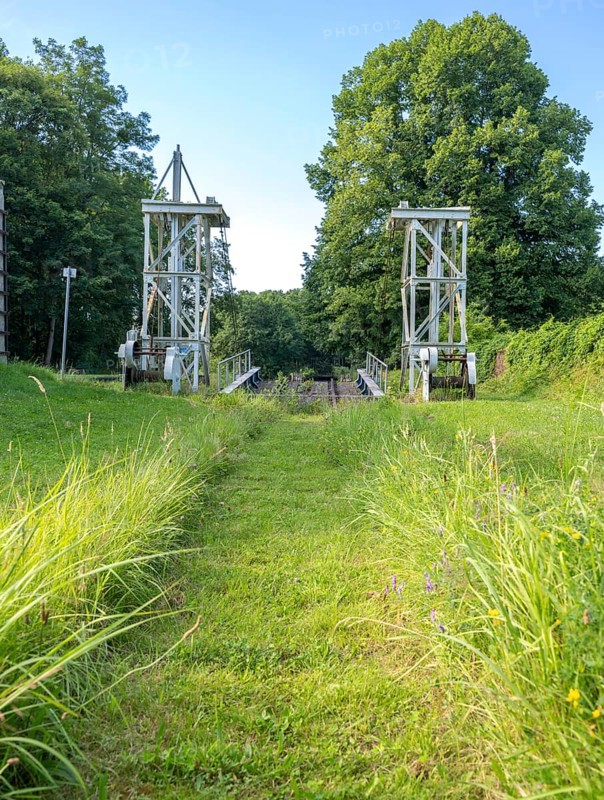Landing stage of the historic railway ferry with overgrown old rails on the banks of the Havel in Fürstnberg/Havel. The ferry service across the Havel began in 1934 and was discontinued in 1993. Since 1993, the ferry has been a listed building in a meadow behind the landing stage, Fürstenberg/Havel, Brandenburg, Germany, Europe