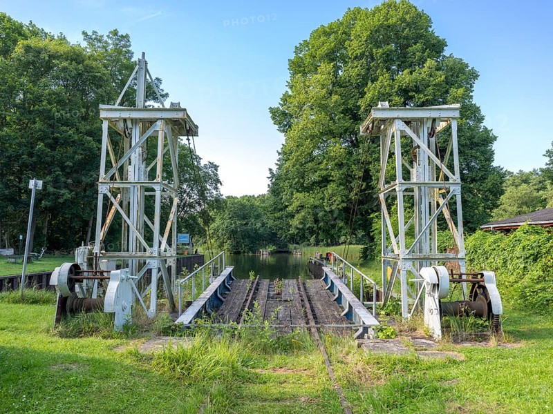 Landing stage of the historic railway ferry with overgrown old rails on the banks of the Havel in Fürstnberg/Havel. The ferry service across the Havel began in 1934 and was discontinued in 1993. Since 1993, the ferry has been a listed building in a meadow behind the landing stage, Fürstenberg/Havel, Brandenburg, Germany, Europe