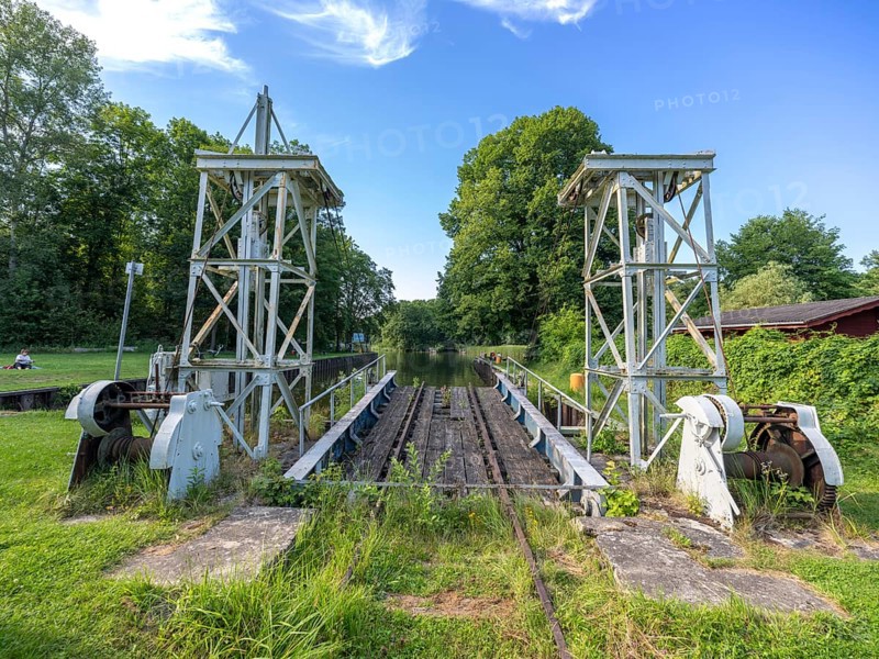 Landing stage of the historic railway ferry with overgrown old rails on the banks of the Havel in Fürstnberg/Havel. The ferry service across the Havel began in 1934 and was discontinued in 1993. Since 1993, the ferry has been a listed building in a meadow behind the landing stage, Fürstenberg/Havel, Brandenburg, Germany, Europe