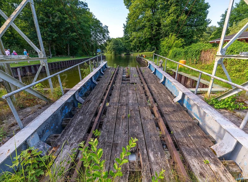 Landing stage of the historic railway ferry with overgrown old rails on the banks of the Havel in Fürstnberg/Havel. The ferry service across the Havel began in 1934 and was discontinued in 1993. Since 1993, the ferry has been a listed building in a meadow behind the landing stage, Fürstenberg/Havel, Brandenburg, Germany, Europe