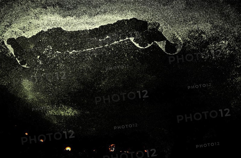 Dark abstract scene with speckles and faint yellow lights, creating a mysterious and eerie atmosphere
