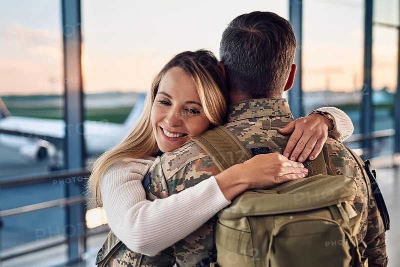 A woman hugs a soldier in an airport area at sunset, AI generated, AI generated