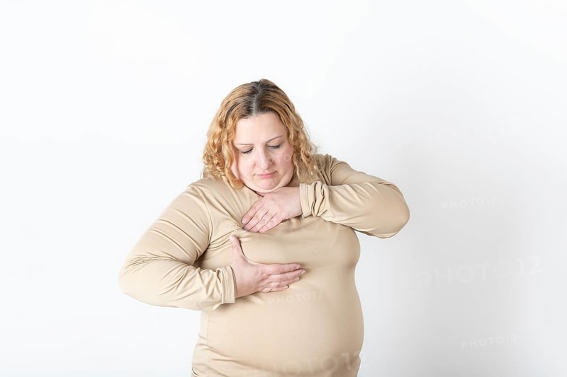 Plus size woman doing a Breast Self-Exam (BSE)