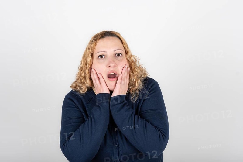 Plus size woman with a look of disgust and surprise grabs her head and looks up
