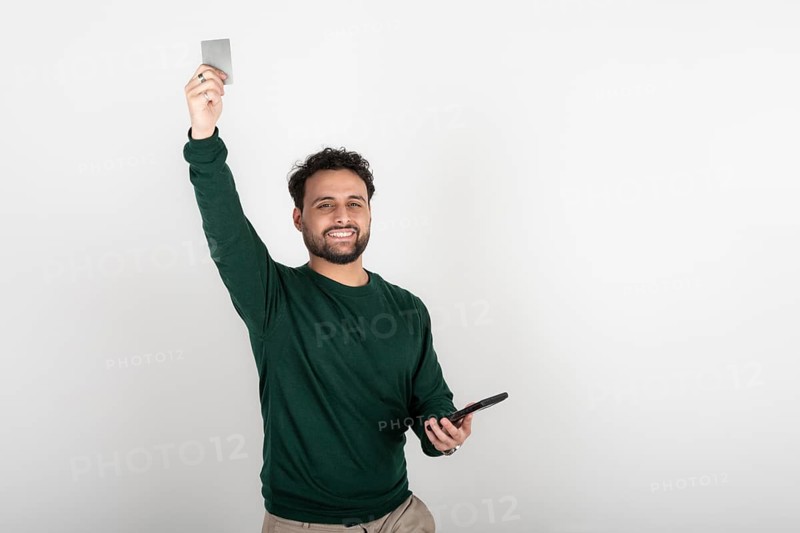 Happy man celebrating an online purchase with his credit card