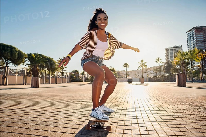 Young woman enjoying a skateboard ride on a sunny day in a city with palm trees, ai generated, KI generated, AI generated