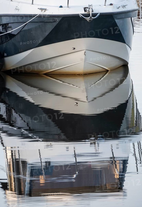 The bow of a ship is reflected in the Tanger river at the harbour at the mouth of the Elbe, Tangermünde, Saxony-Anhalt, Germany, Europe