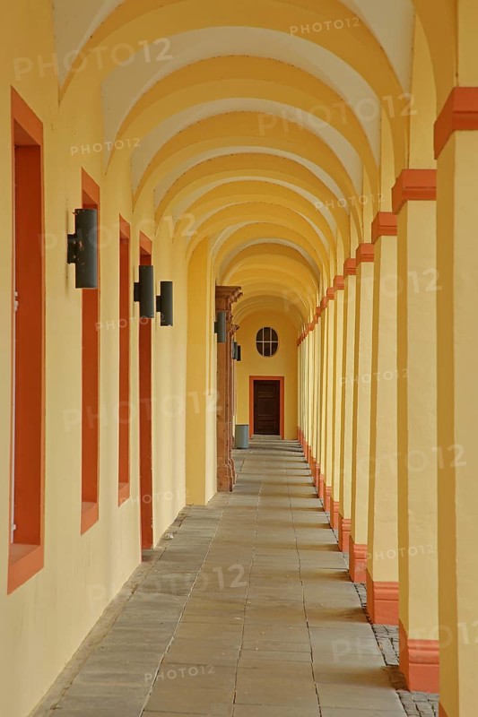Yellow arcade from inside with archways and pillars, University, Lower Castle built 17th century, baroque, long corridor, yellow, vanishing point, row, series, geometric, Siegen, Siegerland, North Rhine-Westphalia, Germany, Europe