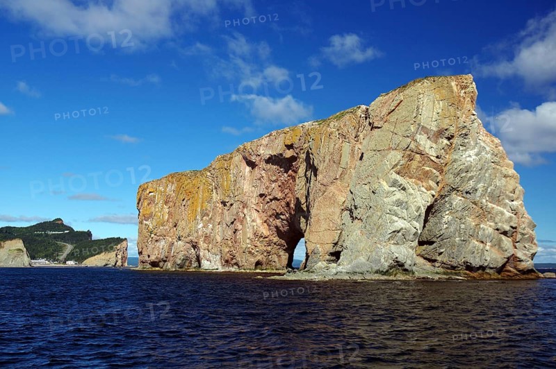Large rocky cliffs in the sea under a blue sunny sky, Rock of Perce, Perce, St. Lawrence River, Gaspesie, Quebec, Canada, North America