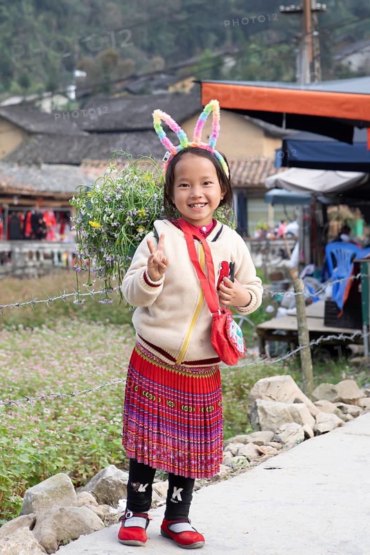 Vietnamese girl with rabbit ears and flowers on her back, Lungcam Cultural Tourist Village, Ha Giang Province, Vietnam, Asia