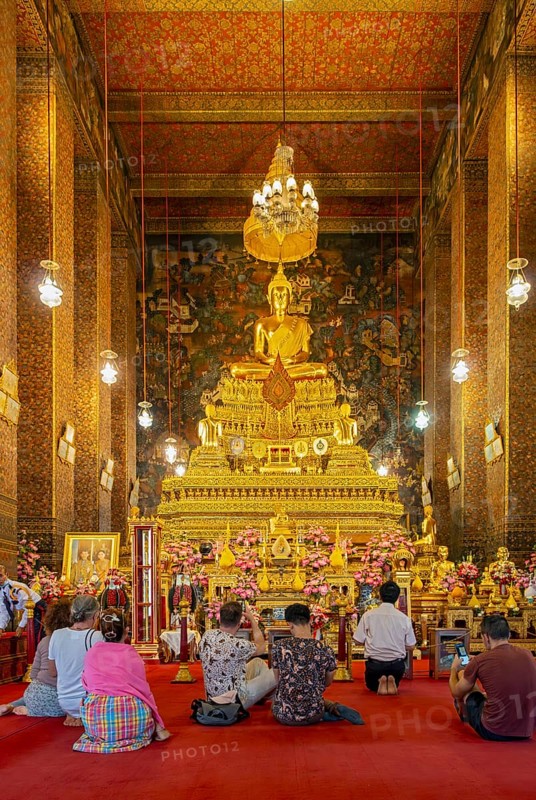 Worshippers oin front of Phra Buddha statue at the Phra Ubosot ordination hall, Wat Pho complex, Bangkok, Thailand, Asia