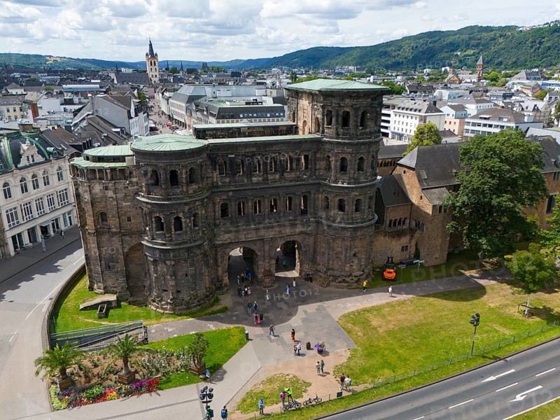 Historical architecture of the Porta Nigra with city panorama, surrounded by mountains and green areas, aerial view, Porta Nigra, Black Gate, Roman city gate, Trier, Rhineland-Palatinate, Germany, Europe