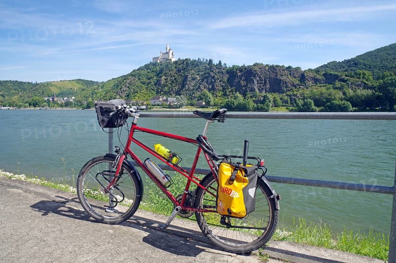 A bicycle stands in front of a railing with a view of the river and a castle on a hill, Middle Ages, Marksburg, Rhine, Rhineland-Palatinate, Germany, Europe