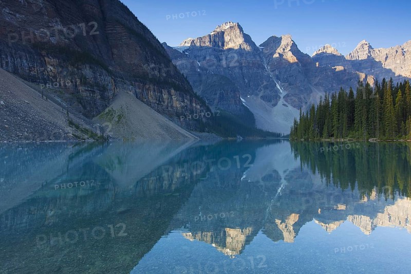 Mountains reflected in glacial water of Moraine Lake in the Valley of the Ten Peaks, Banff National Park, Alberta, Canada, North America